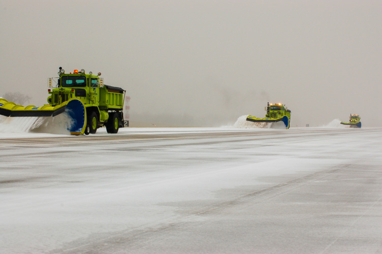 Image of three airport snow plows